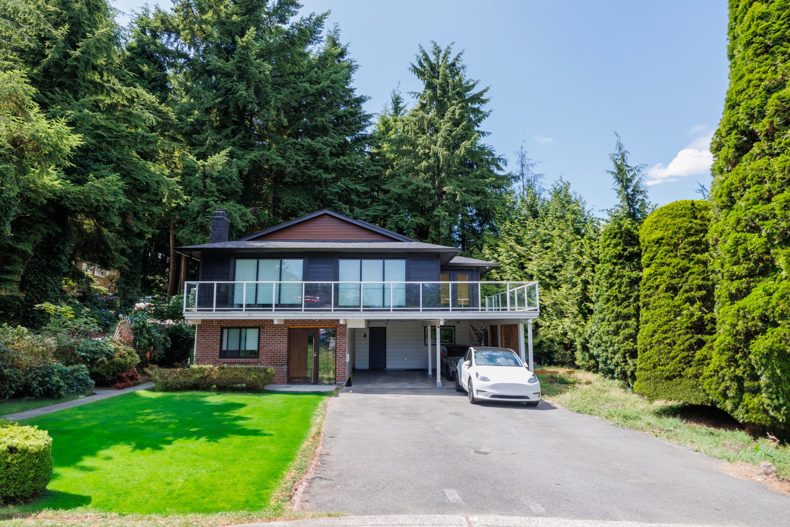 Custom residential home exterior surrounded by mature trees in Greater Vancouver